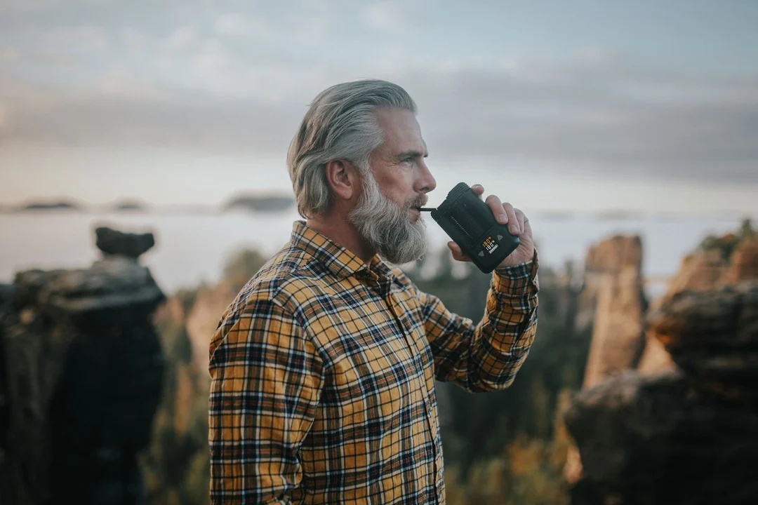 Mann nutzt den Mighty+ Vaporizer vor einer Felslandschaft