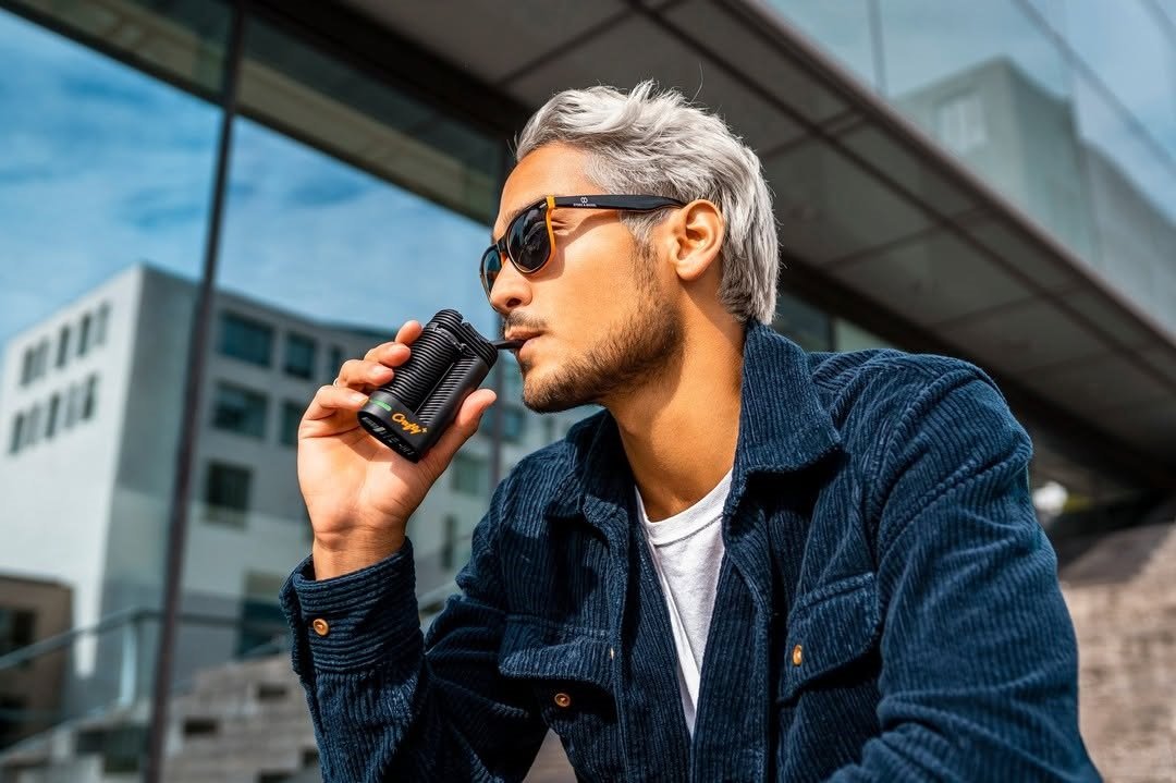 Top Premium-Vaporizer unter 200 Euro: Mann nutzt tragbaren Cannabis-Vaporizer im Freien.