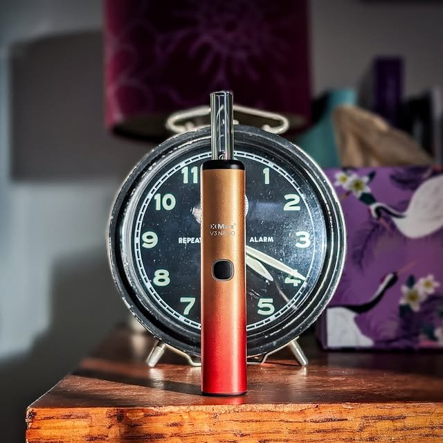 XMAX V3 Nano: günstiger tragbarer Stift-Cannabis-Vaporizer für Kräuter steht im Sonnenlicht auf einem Tisch.