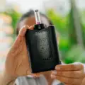 Eine Person hält den Yllvape Angus Enhanced mit Glasaufsatz vor die Kamera