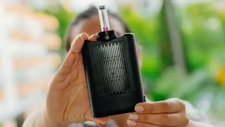 Eine Person hält den Yllvape Angus Enhanced mit Glasaufsatz vor die Kamera